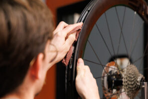Un mecánico limpiando una llanta de bicicleta.